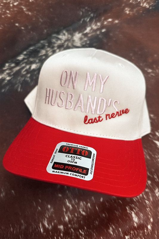 On My Husband’s Last Nerve embroidered trucker hat with red bill and neutral crown by Rustic Ridge Customs & Co