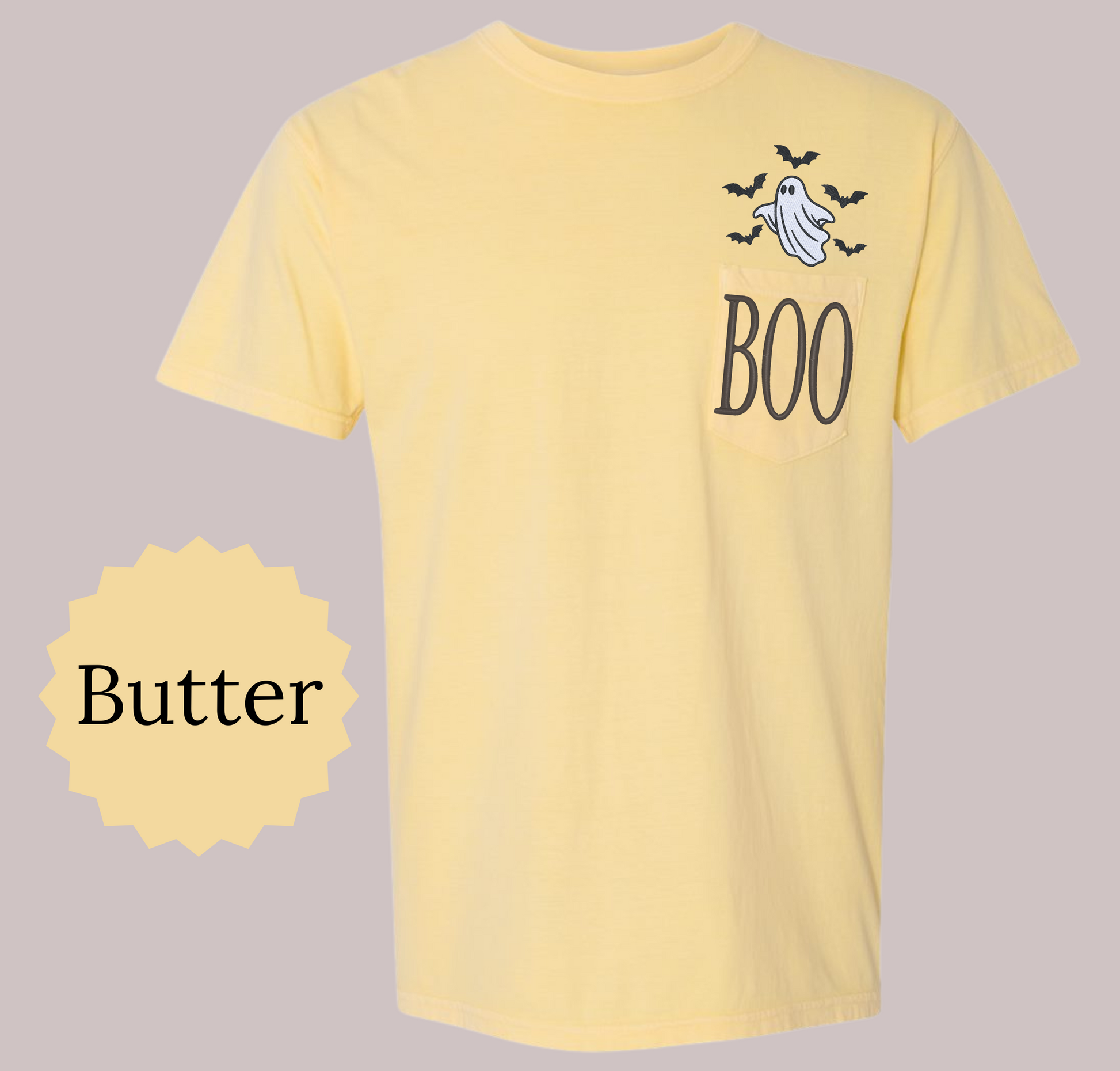 A pale butter-yellow short-sleeve t-shirt with a chest pocket, featuring a graphic of a white ghost, three black bats, and the word 'BOO' in dark lettering. A yellow scalloped circle overlay on the left reads 'Butter'.
