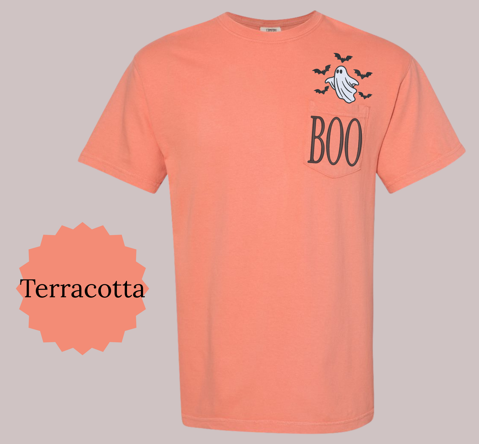 A terracotta orange short-sleeve t-shirt with a Halloween graphic on the left chest featuring a ghost, bats, and the word 'BOO'. A circular badge on the bottom left reads 'Terracotta' to indicate the color name.