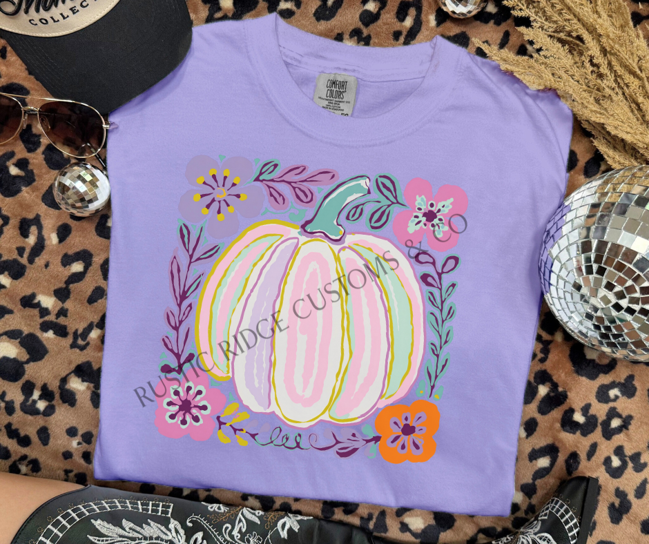 Pastel Pumpkin graphic tee in Orchid Comfort Colors with colorful floral pumpkin design