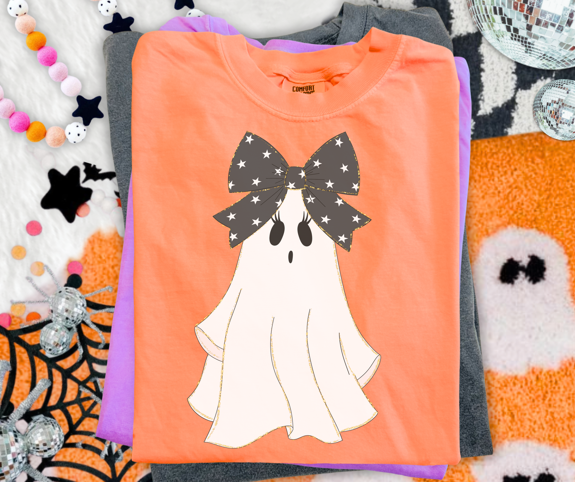Preppy Bow Ghost Graphic Tee on Neon Cantaloupe Comfort Colors with a white ghost and oversized black star bow