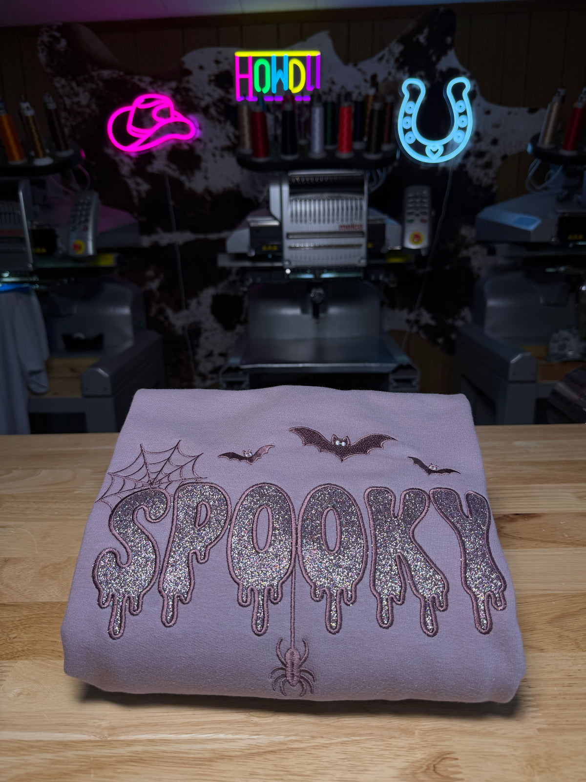 Mauve embroidered Halloween sweatshirt featuring glitter SPOOKY lettering with bats, spiderweb and hanging spider details.