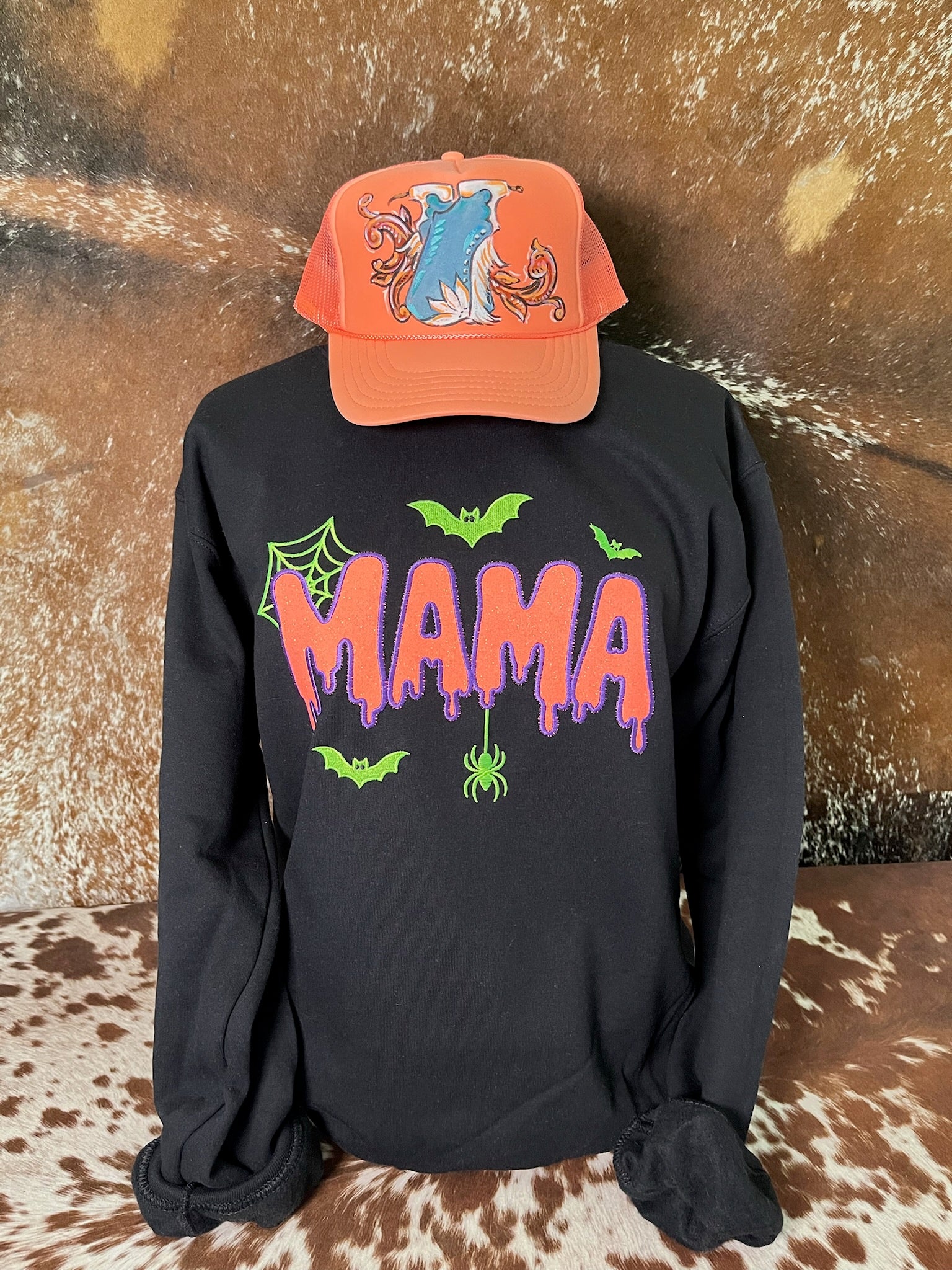 Black Spooky Mama Halloween sweatshirt with glitter embroidered orange MAMA lettering, green bats, spiderweb and hanging spider.