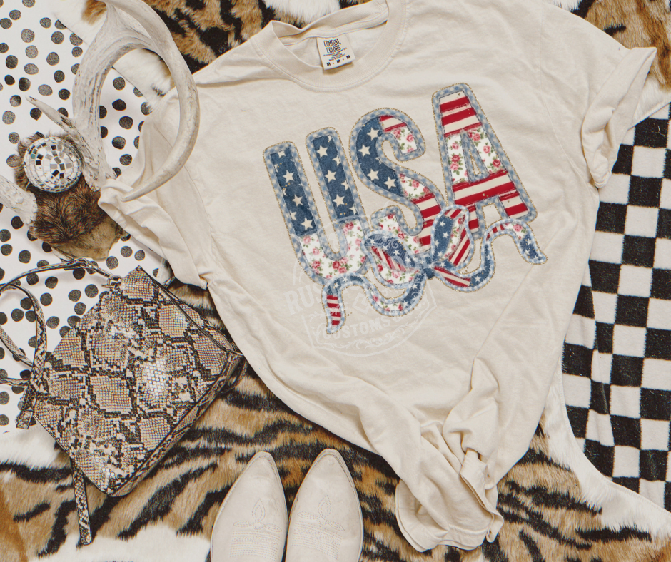 USA patriotic bow graphic tee with Americana patchwork lettering on Comfort Colors shirt by Rustic Ridge Customs & Co