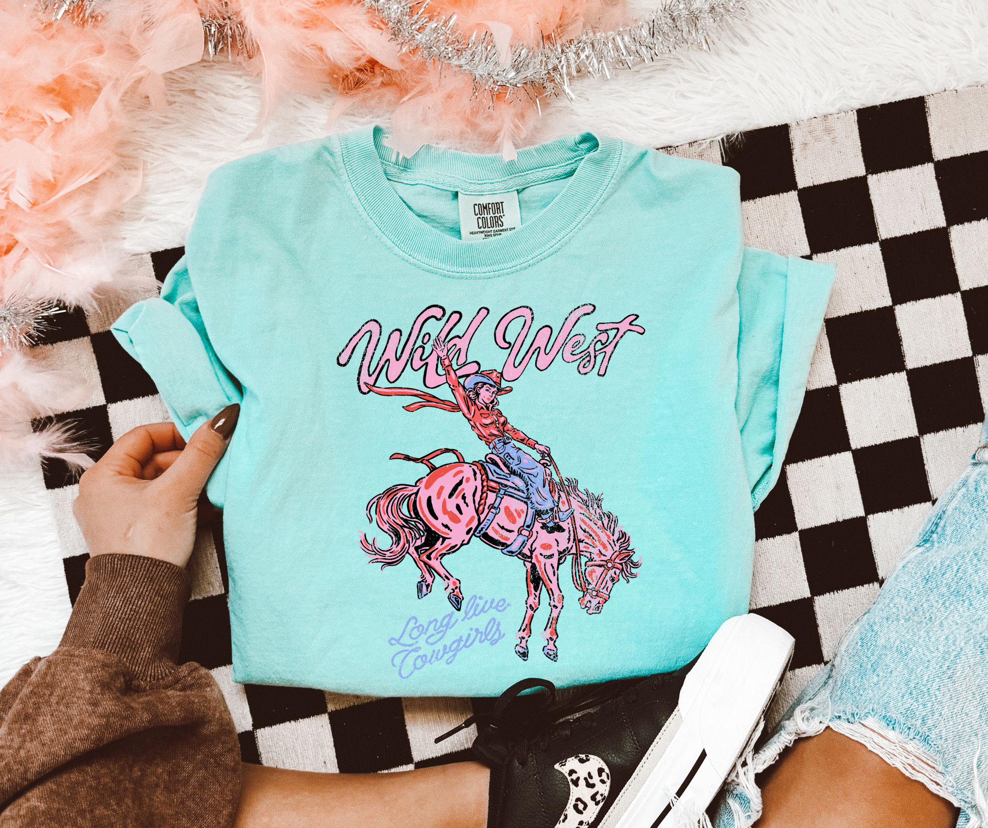 Wild West Cowgirl Graphic Tee on a Chalky Mint Comfort Colors shirt featuring a pink cowgirl bronc rider design