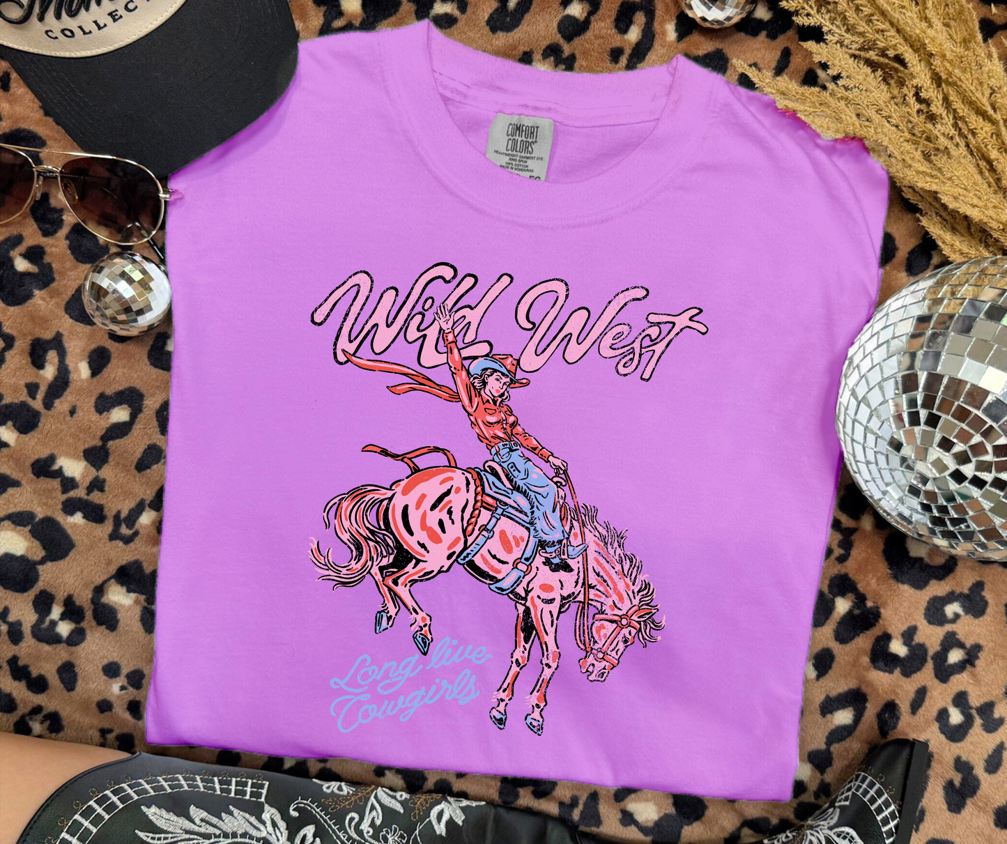 Wild West Cowgirl Graphic Tee on a Neon Violet Comfort Colors shirt featuring a retro rodeo cowgirl design